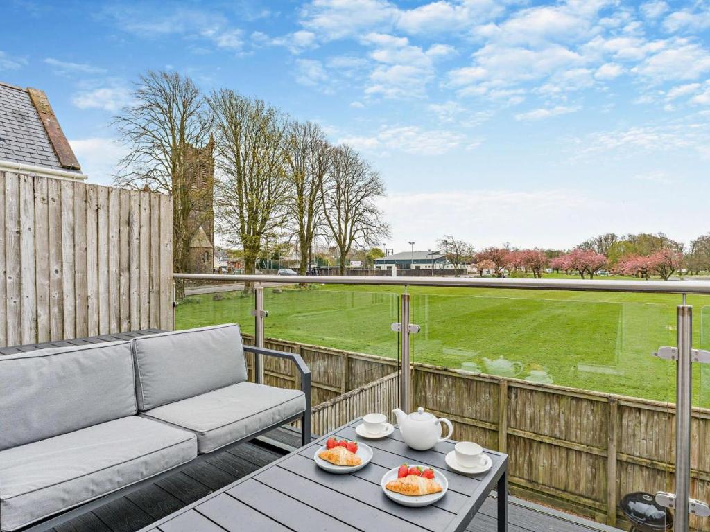 a patio with a couch and a view of a field at 2 Bed in Castle Douglas oc-59638 in Castle Douglas