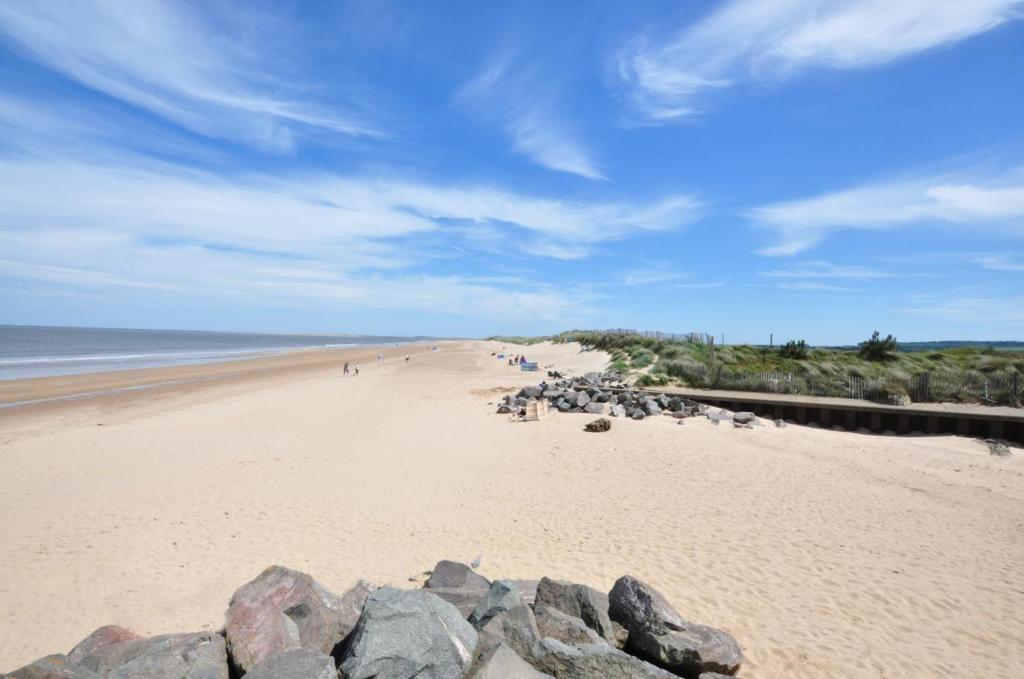 a beach with a group of people walking on it at 3 Bed in Brancaster oc-2153 in Brancaster
