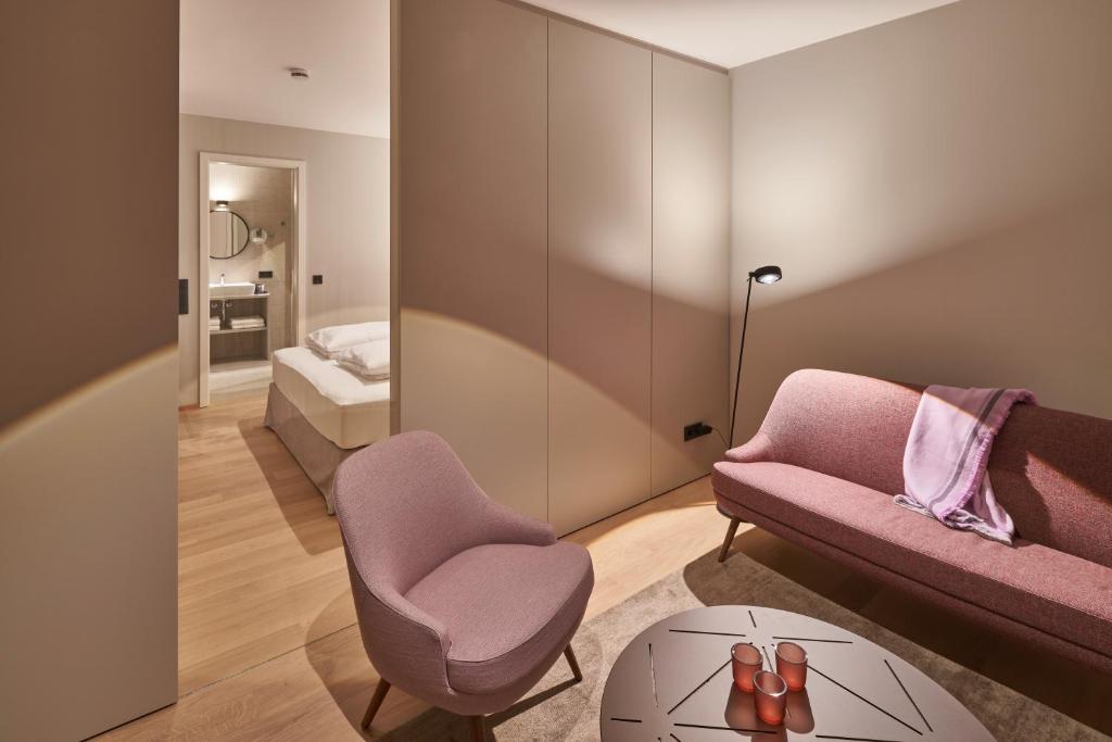 a living room with a couch and a chair and a table at Michels Dependance des Hotel Misan in Norderney