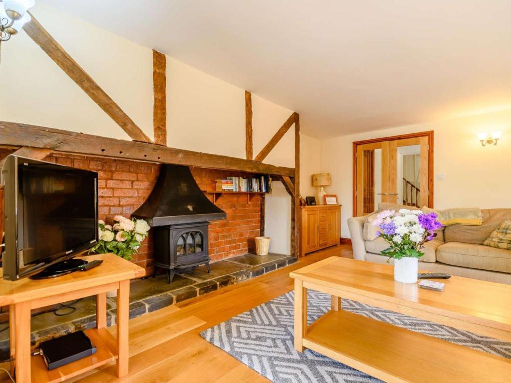 a living room with a fireplace and a tv at 3 Bed in Evesham oc-89477 in Bretforton