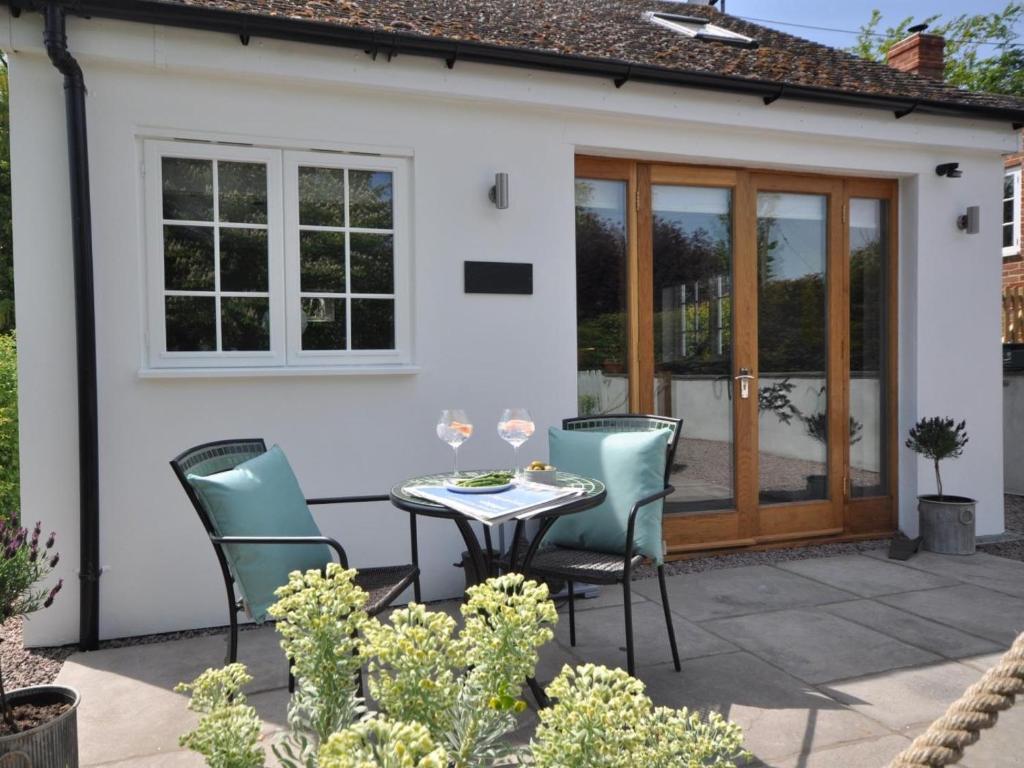 a patio with a table and chairs in front of a house at 1 Bed in Banbury oc-57103 in Upper Brailes