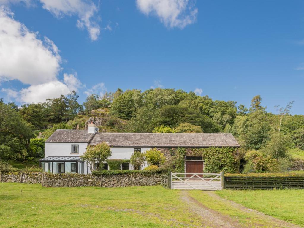 a white house with a stone wall and a fence at 4 Bed in Broughton-in-furness oc-sz183 in Ulpha