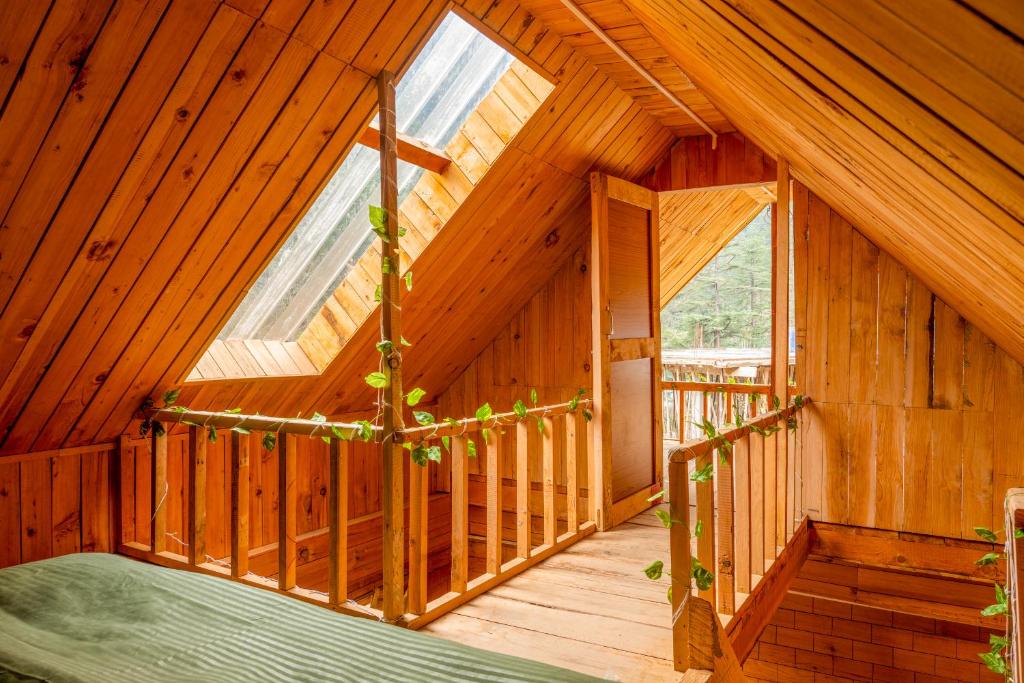 an inside view of a wooden cabin with windows at Riverside Mudhouse Duplex Cottage by Kahani in Jibhi