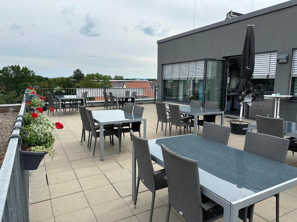 eine Terrasse mit Tischen und Stühlen an einem Gebäude in der Unterkunft Hotel Efcannos in Vechelde