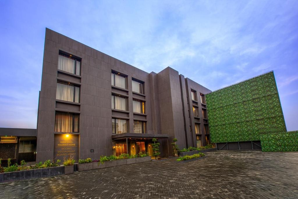 a large building with a green wall next to it at Purple Elephant Luxury Business Hotel in Cochin