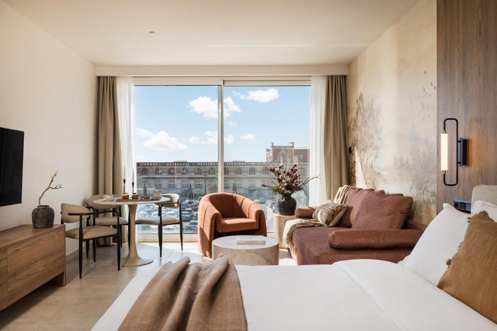 a hotel room with a bed and a large window at PortoVista Luxury Urban Suites by BiNoBi! in Thessaloniki