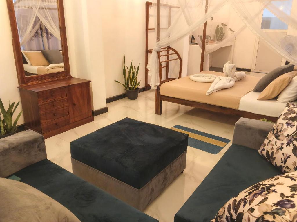 a living room with two beds and a mirror at The wave Dickwella in Dickwella