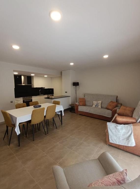 a living room with a couch and a table and chairs at Apartamentos Elvira Valderrobres in Valderrobres