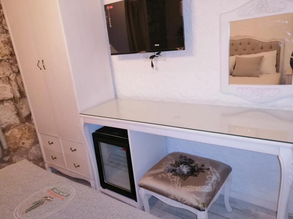 a dressing table with a stool and a mirror at kaktüshan otel in Alaçatı
