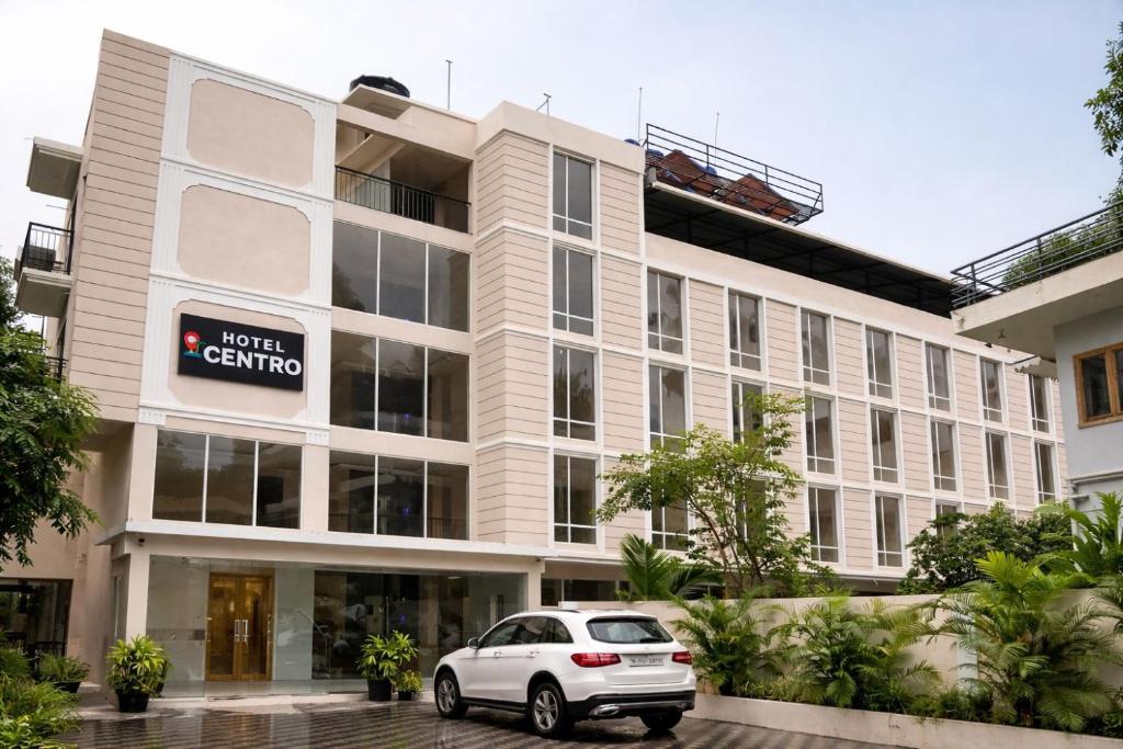 a white car parked in front of a building at Hotel Centro in Calangute