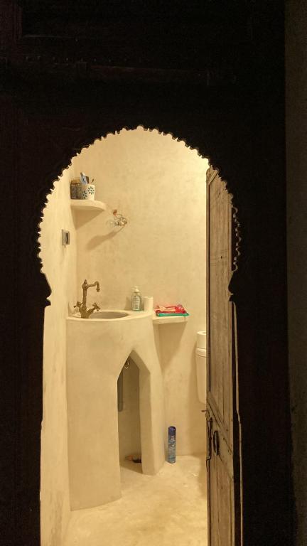 an open door to a bathroom with a sink at Riad mama aicha in Asilah