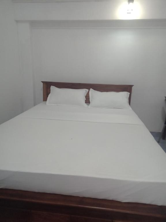 a large white bed with two pillows on it at Robert's-stay in Katunayaka