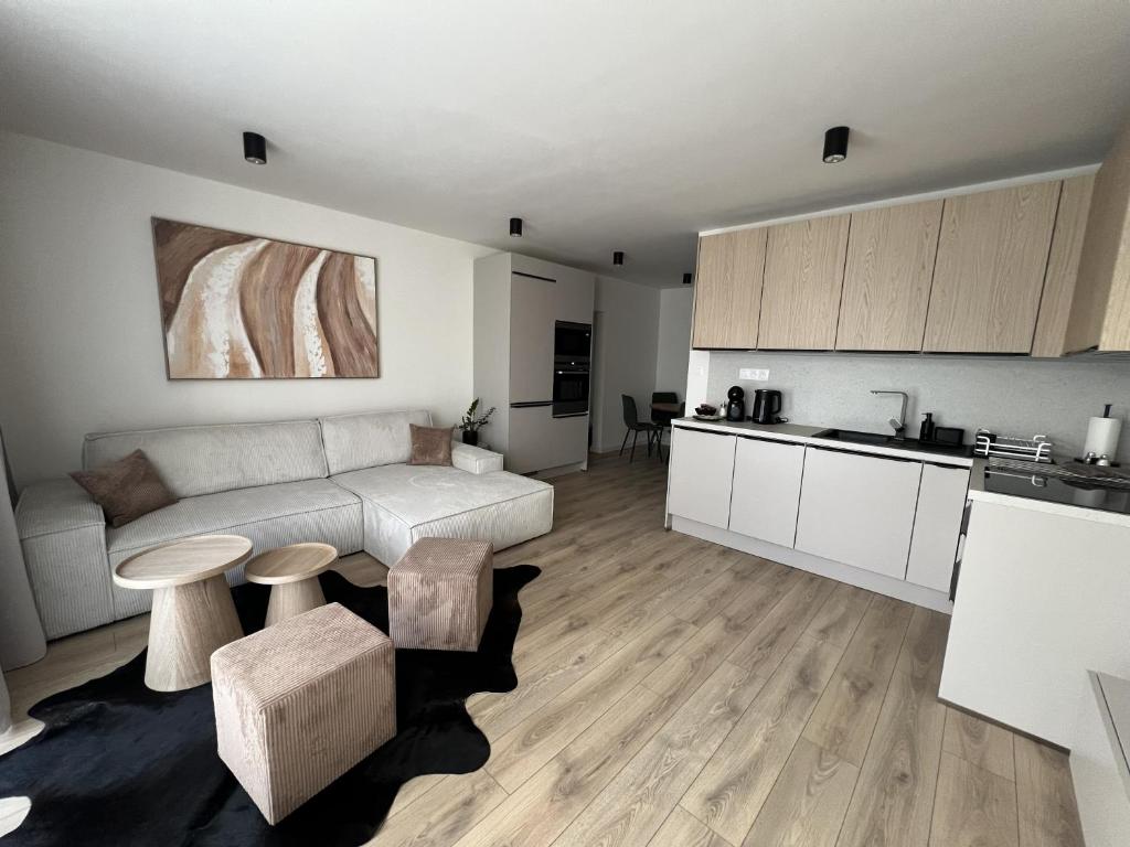 a kitchen and a living room with a couch and a table at Apartmán LÝRA Trenčín in Trenčín