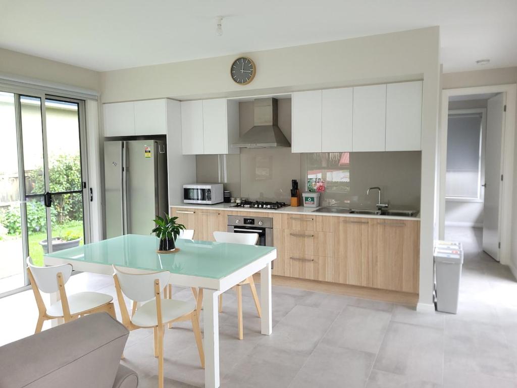 a kitchen with a table and chairs in a room at Cosy Private Modern Flat in Epping