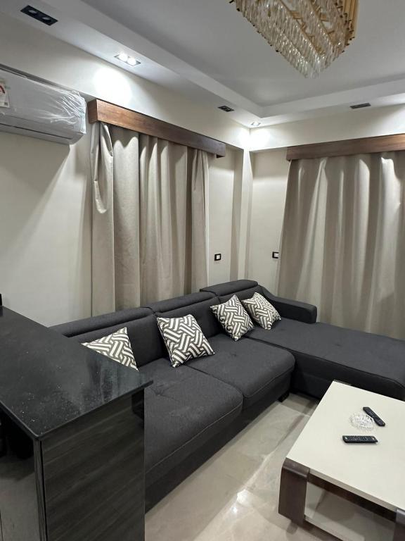 a living room with a black couch and a table at Sharm Glow Villa in Sharm El Sheikh
