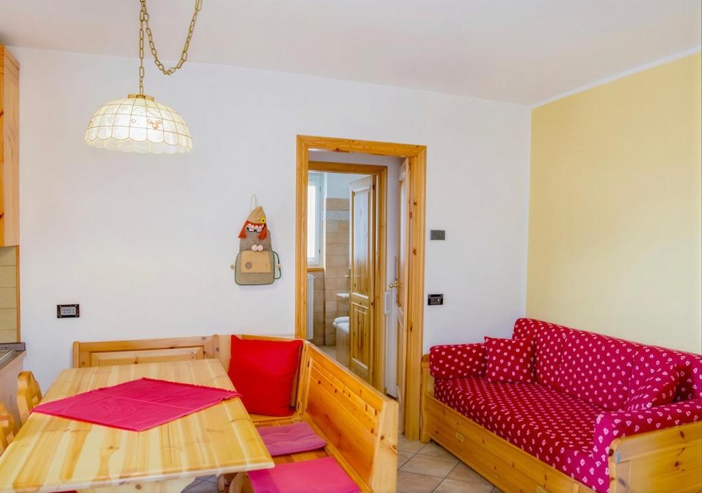 a living room with a couch and a table at Ca' Maria - Casa in Scalve in Schilpario