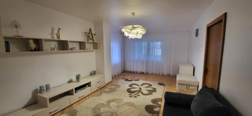 a living room with a couch and a chandelier at Sara Apartment Centru Râmnicu Vâlcea in Râmnicu Vâlcea