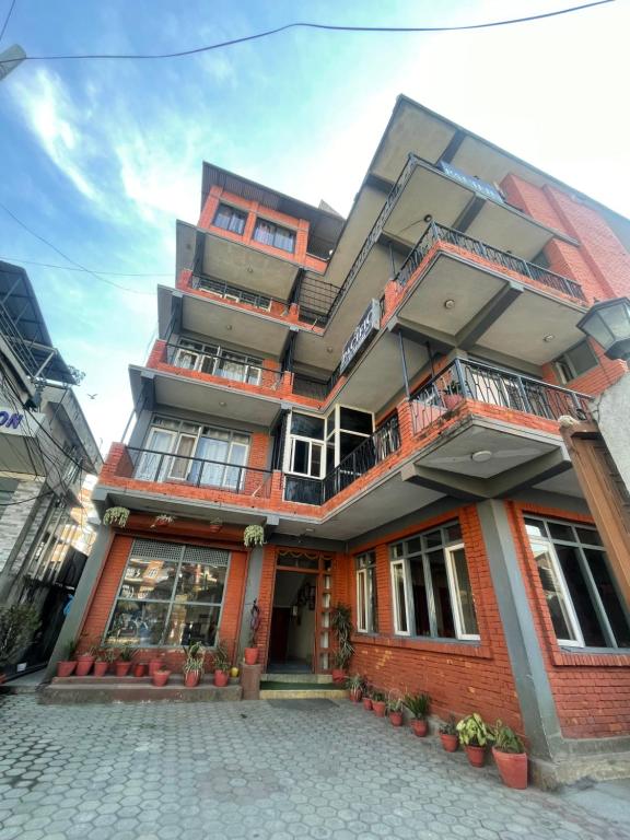 a red brick building with plants in front of it at Pacific Guest House in Kathmandu