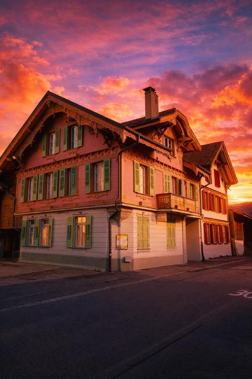 a large wooden house with a sunset in the background at Apartment Jolie in Interlaken
