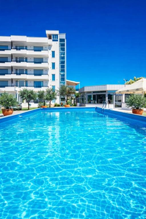 a large swimming pool in front of a building at Sahat Kula Residence Hotel in Ulcinj