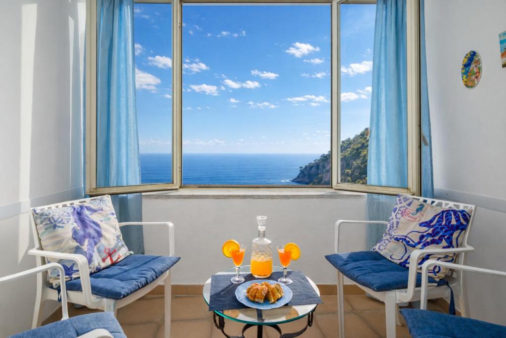 a room with two chairs and a table and a large window at A la casa del cavaliere in Positano