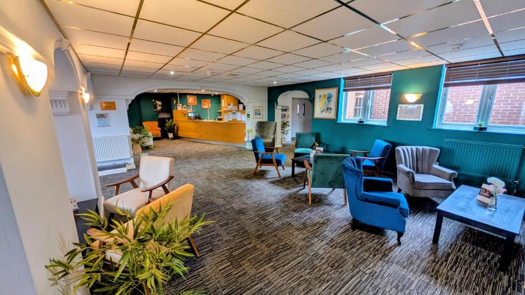 a waiting room with blue chairs and tables at Quality Hotel Coventry in Coventry