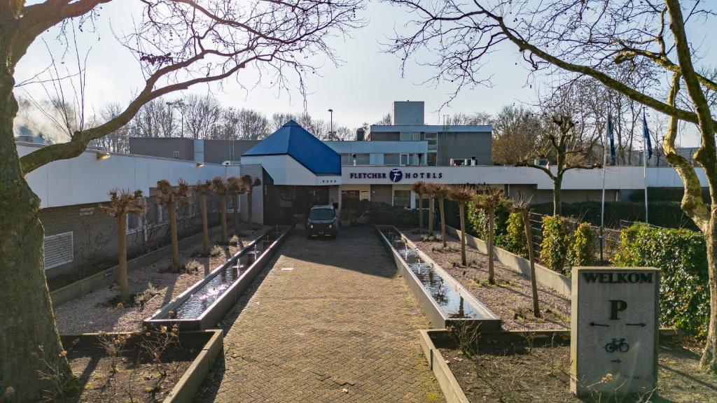 a building with a parking lot in front of it at Fletcher Resort-Hotel Zutphen in Zutphen