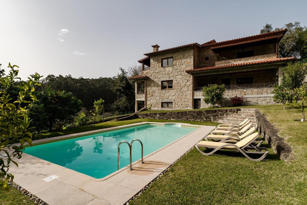 a swimming pool in front of a house at Casa Das Flores in Amares