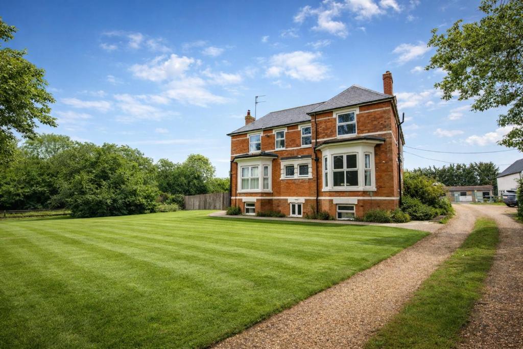 an old brick house with a large lawn at Group Accommodation - Rushden A6 Manor House - Private Gated -Sleeps 15 - Secure Parking in Rushden