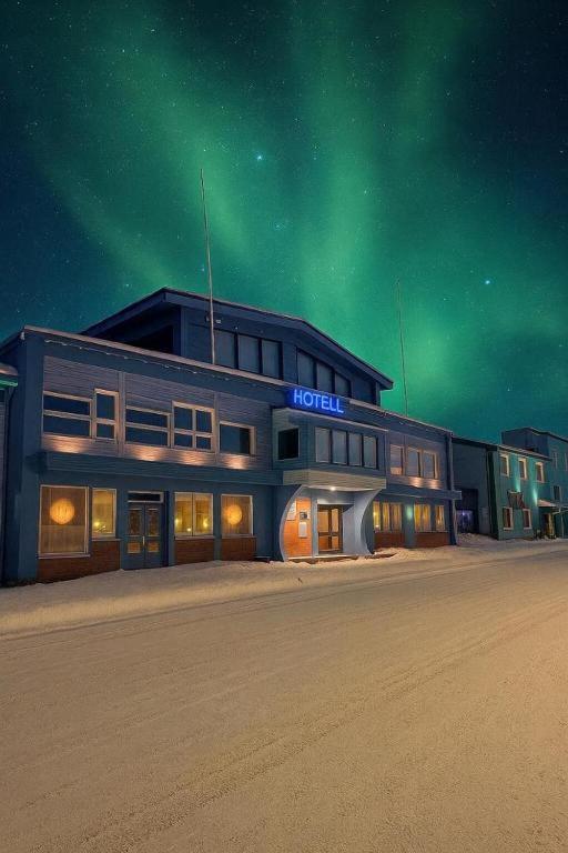 a building with a sign that reads hotel under the green sky at Marina Hotel Sortland in Sortland