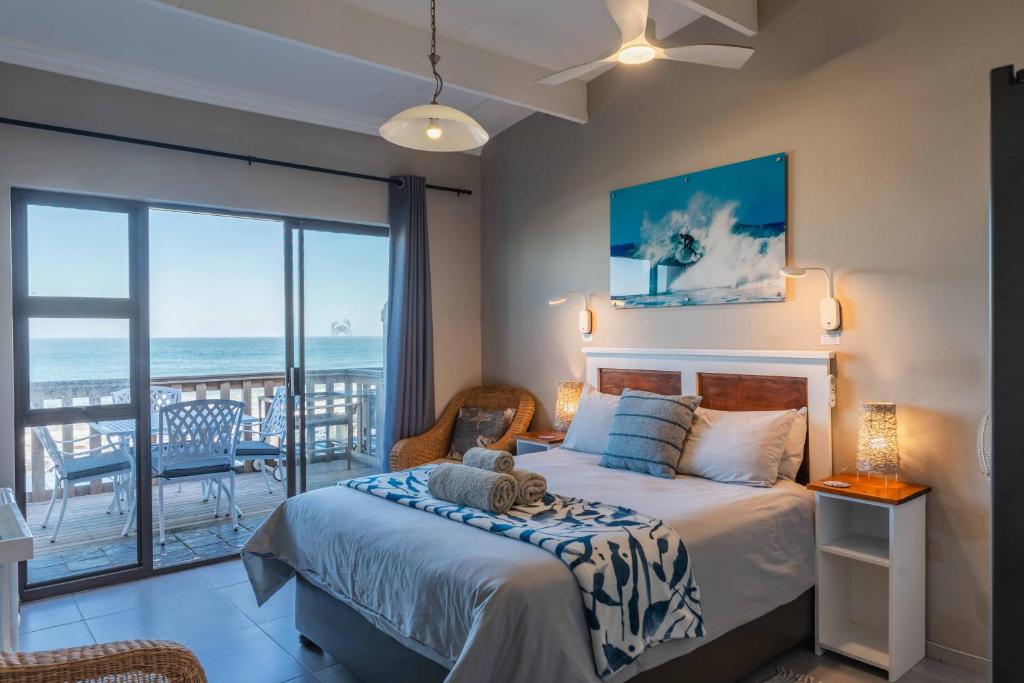 a bedroom with a bed with a view of the ocean at Mitford-on-Sea in Morganʼs Bay