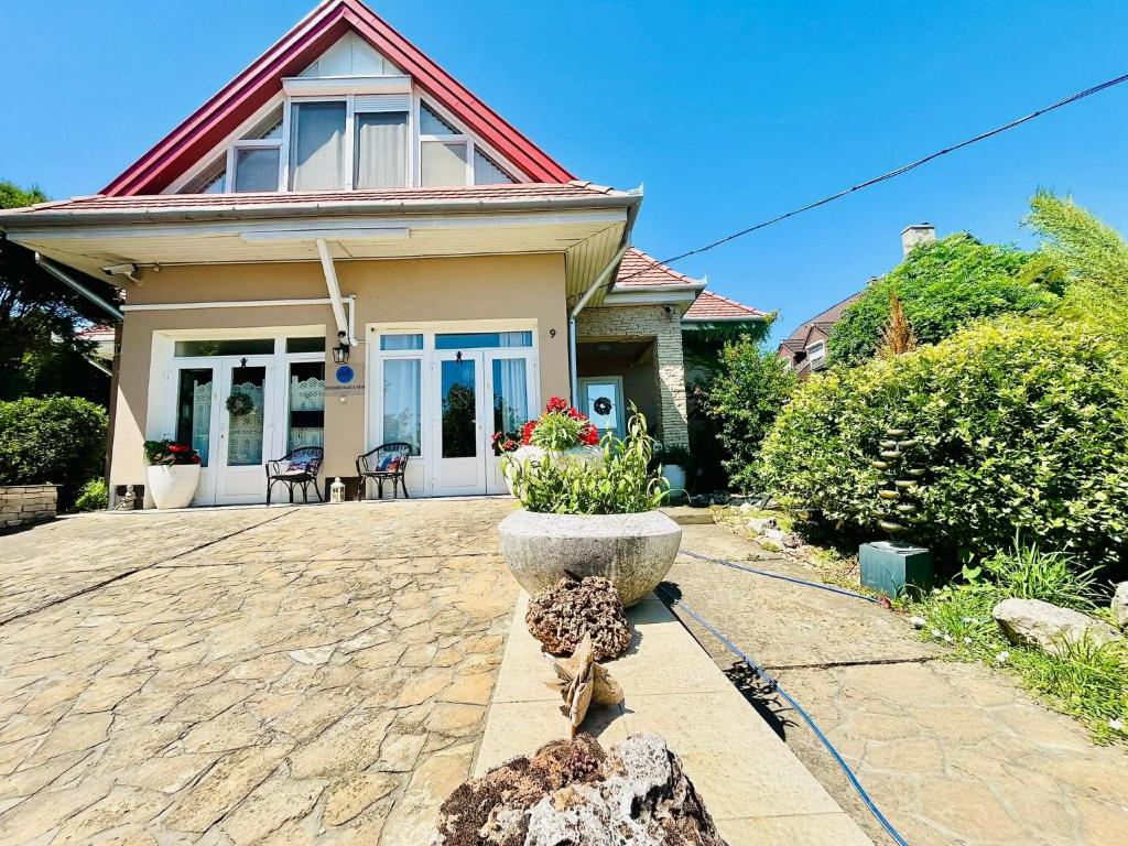 a house with a stone patio in front of it at Nirvana Apartman in Balatonberény