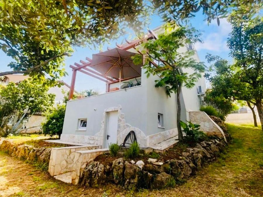 a white house with a tree in front of it at El Dorado in Premantura