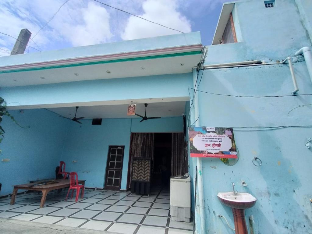 a blue building with a table and a sink at Gyan Homestay in Bareilly