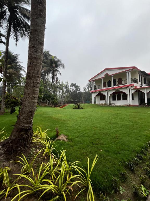 a large house with a palm tree in front of it at Prangan - The Villa in Chākdaha