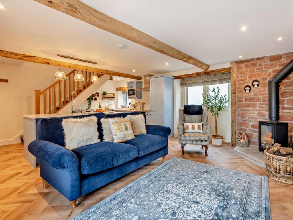 a living room with a blue couch and a kitchen at 1 Bed in Carlisle oc-94538 in Scaleby