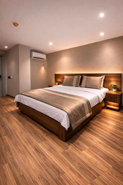 a large bed in a bedroom with a wooden floor at Palmero Butik Otel in Çiftlikköy