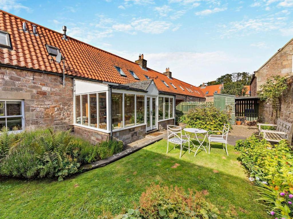 a garden with a table and chairs in a yard at 4 Bed in Chathill oc-93702 in Ellingham