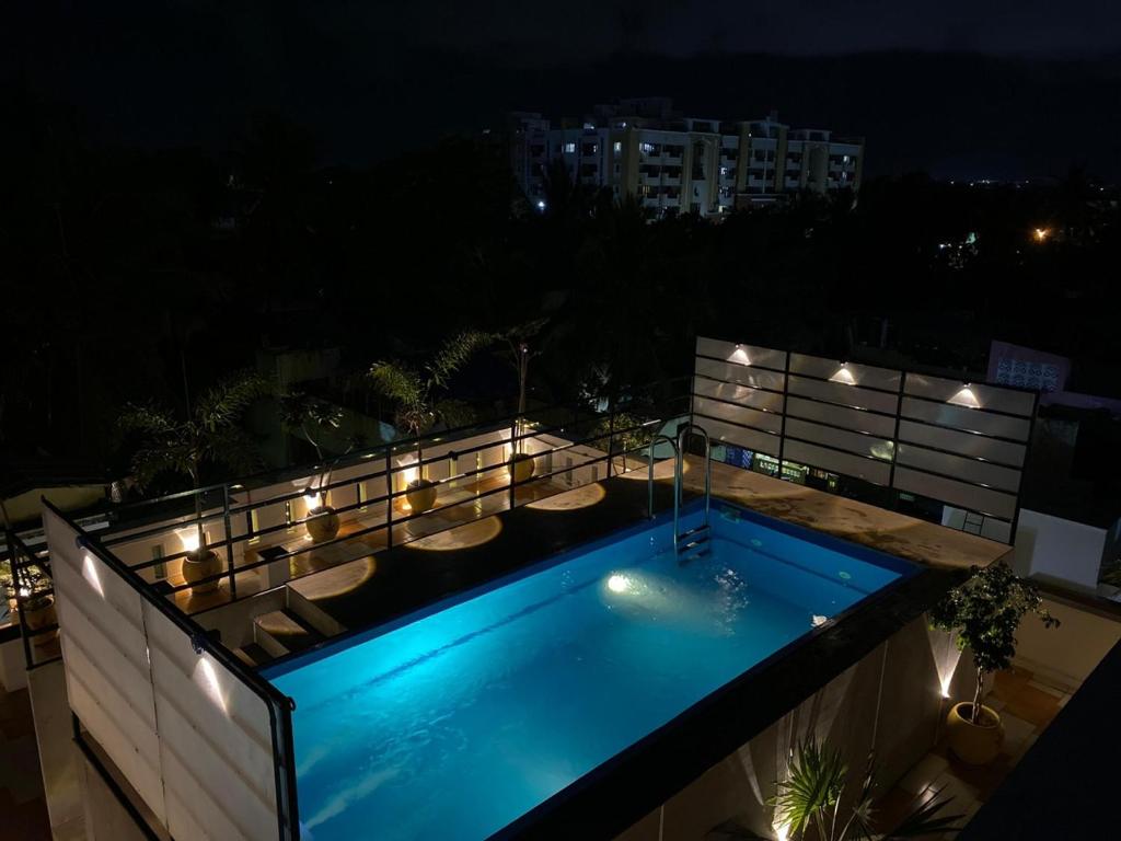 a swimming pool on the roof of a building at night at Villa Shakti - TIE Hotels in Pondicherry