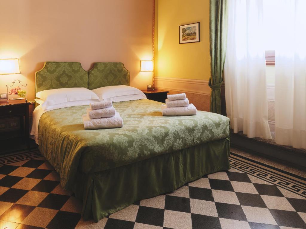 a bedroom with a bed with two pillows on it at Hotel I Portici in Arezzo