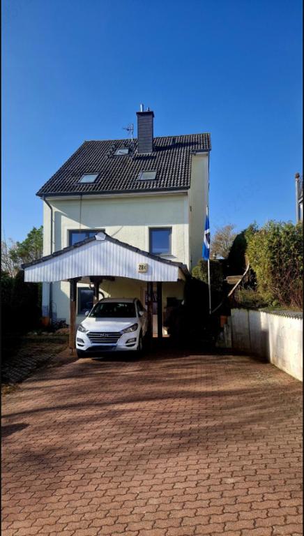 a car parked in front of a house with a roof at Staar in Hohenfelde