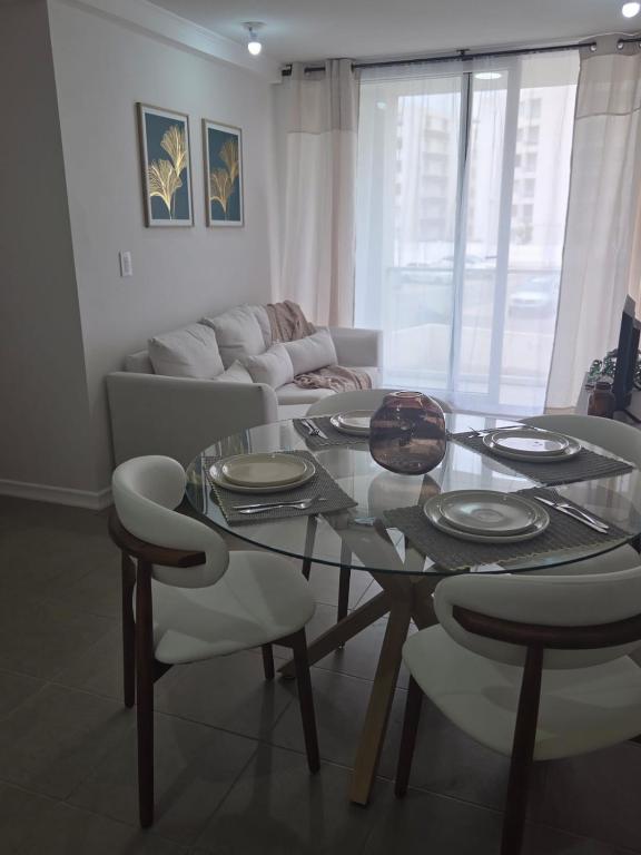 a living room with a glass table and chairs at Pacific blue cómodo y familiar in La Serena
