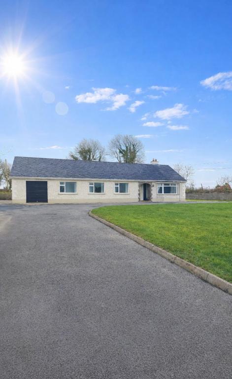 a large white house with a driveway at Cootehall in Boyle