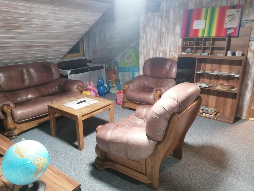 a living room with leather chairs and a table at ANEMA Ferienwohnung in Bayerisch Eisenstein