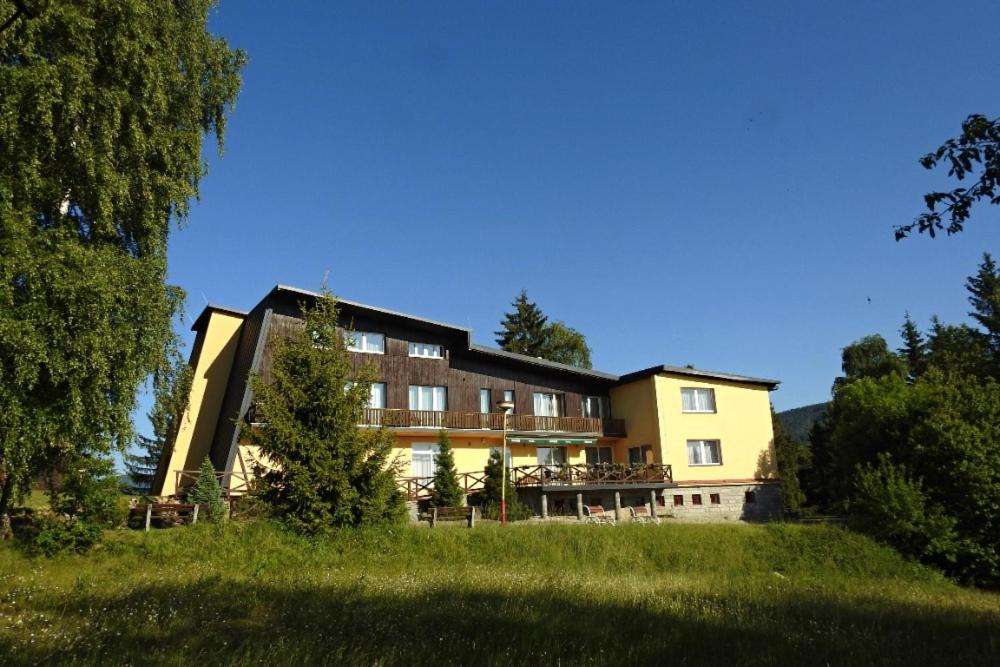 ein Gebäude auf einem Hügel mit einem grünen Feld in der Unterkunft Wellness Penzion Kotár in Prostřední Bečva