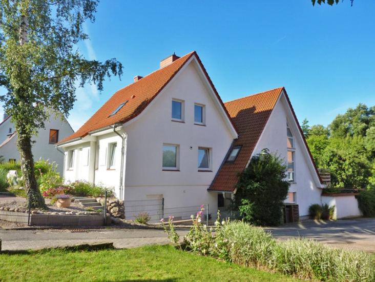 una casa blanca con techo naranja en Ferienwohnung Am Schwanensee, en Plön