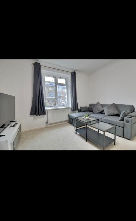 a living room with a couch and a table at Flat in Portsmouth in Portsmouth
