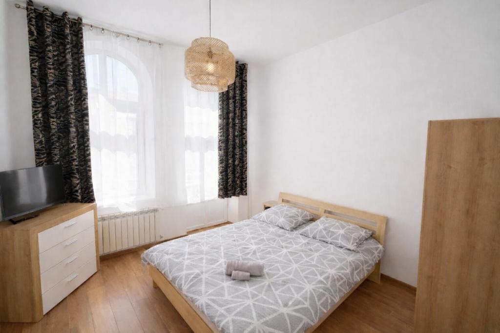 a bedroom with a bed with a teddy bear on it at Apartament Panorama Centrum in Przemyśl