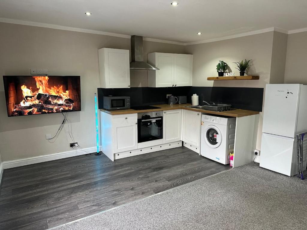 a kitchen with a stove and a fire in the wall at Modern 2 Bed Apartment, Sleeps 4 in Bolton