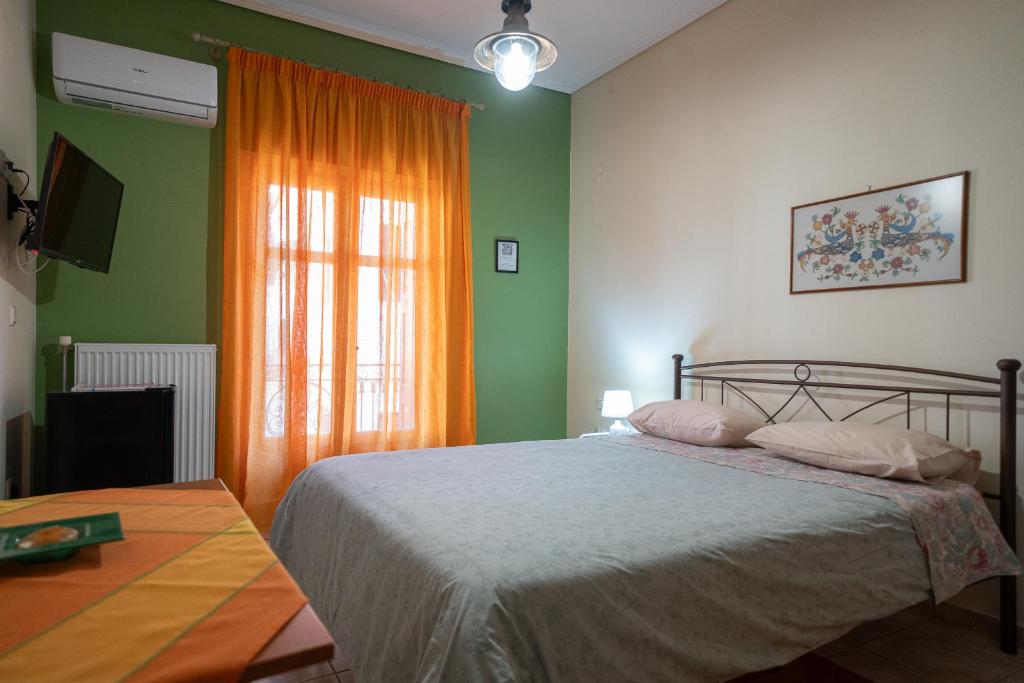a bedroom with a bed with an orange curtain at Delphian Colors - Orange Edition by Filos Inc in Delphi